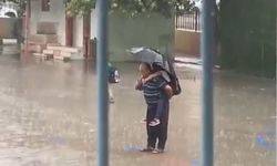 Dede torununu sırtına alarak yağmur altında İstiklal Marşı okudu